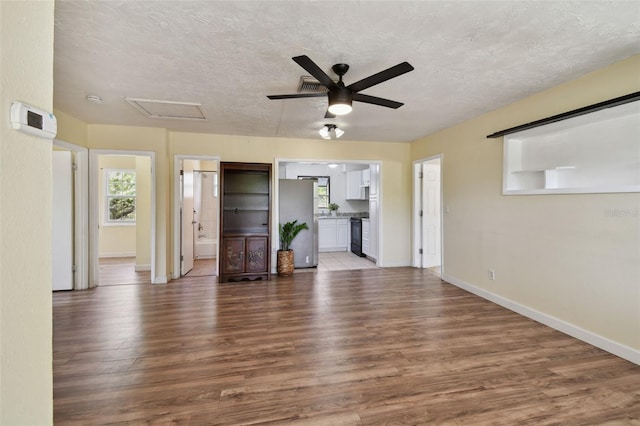 1810 77th Ave N, Saint Petersburg, FL 33702 - unfurnished living room featuring wood finished floors, ceiling fan, attic access, baseboards, and a textured ceiling