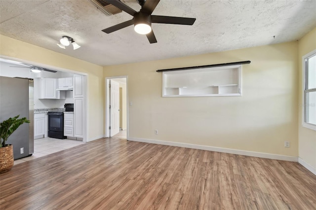 1810 77th Ave N, Saint Petersburg, FL 33702 - unfurnished living room with ceiling fan, light wood-type flooring, baseboards, and a textured ceiling