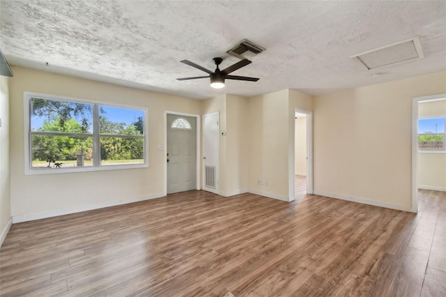 1810 77th Ave N, Saint Petersburg, FL 33702 - spare room with wood finished floors, attic access, baseboards, ceiling fan, and a textured ceiling