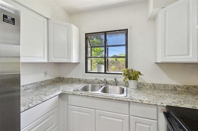 1810 77th Ave N, Saint Petersburg, FL 33702 - kitchen featuring a sink, stainless steel fridge, white cabinets, and light countertops