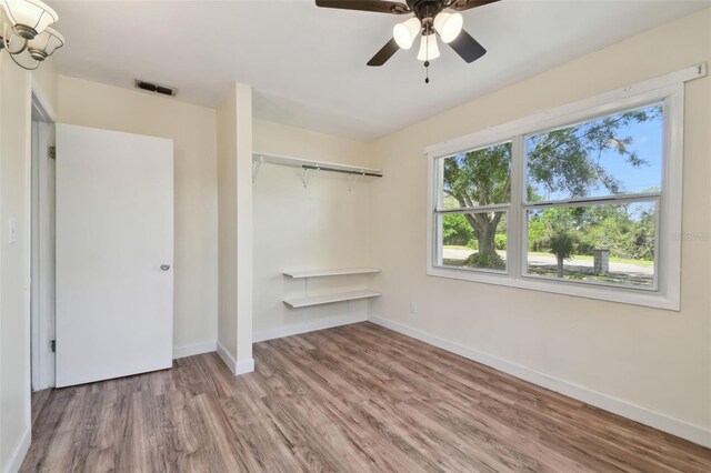 1810 77th Ave N, Saint Petersburg, FL 33702 - unfurnished bedroom with wood finished floors, baseboards, a closet, and a ceiling fan