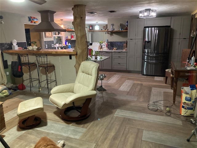 2912 Case Ave, Bradenton, FL 34207 - kitchen with stainless steel fridge, open shelves, gray cabinetry, and a kitchen breakfast bar