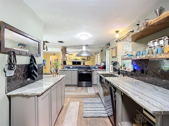 2912 Case Ave, Bradenton, FL 34207 - kitchen with appliances with stainless steel finishes, gray cabinetry, open shelves, a peninsula, and light stone counters