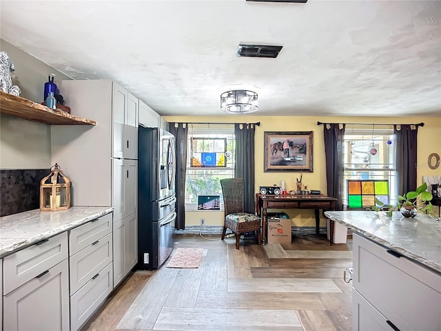 2912 Case Ave, Bradenton, FL 34207 - kitchen with stainless steel fridge, open shelves, and light stone countertops