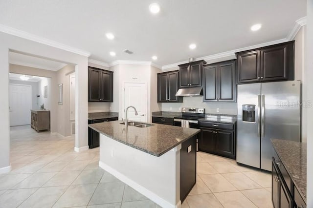 kitchen featuring appliances with stainless steel finishes, a sink, under cabinet range hood, dark stone countertops, and light tile patterned floors