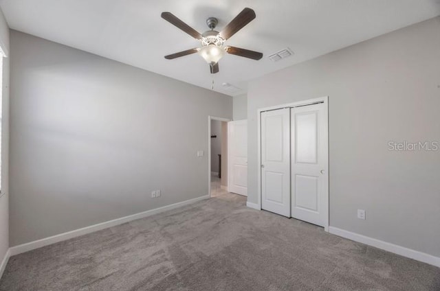 unfurnished bedroom with carpet floors, a closet, baseboards, and ceiling fan