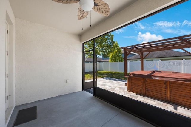 unfurnished sunroom featuring a hot tub and a ceiling fan