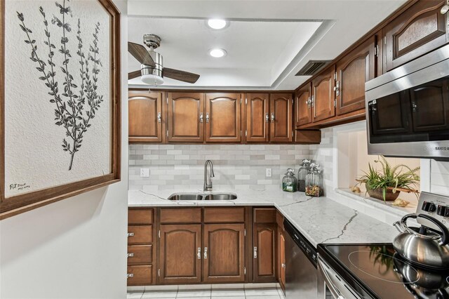 1 Boca Ciega Point Blvd Unit 310, Saint Petersburg, FL 33708 - kitchen featuring a sink, appliances with stainless steel finishes, decorative backsplash, and light stone counters