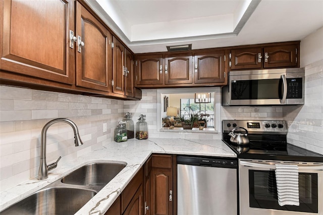 1 Boca Ciega Point Blvd Unit 310, Saint Petersburg, FL 33708 - kitchen with stainless steel appliances, a sink, backsplash, and light stone countertops