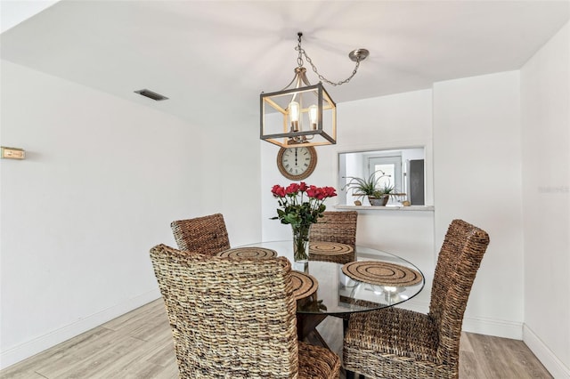 1 Boca Ciega Point Blvd Unit 310, Saint Petersburg, FL 33708 - dining space with a chandelier, light wood-style flooring, and baseboards