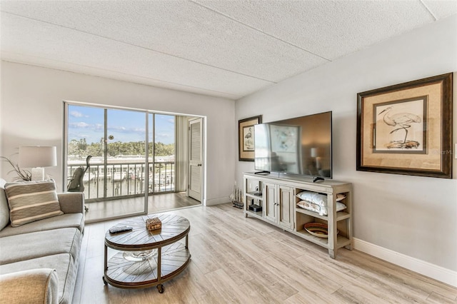 1 Boca Ciega Point Blvd Unit 310, Saint Petersburg, FL 33708 - living area featuring baseboards, light wood-type flooring, and a textured ceiling