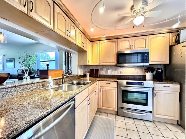 kitchen with appliances with stainless steel finishes, a sink, light tile patterned flooring, light brown cabinets, and track lighting