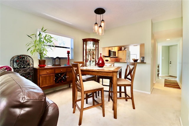 dining space with light carpet and baseboards