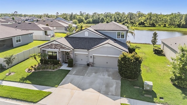 view of front of property featuring driveway, a garage, a water view, a shingled roof, and a residential view