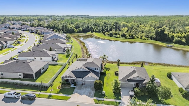 aerial view of residential area with a forest and a nearby body of water