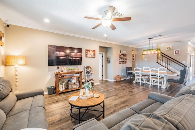 living area featuring ceiling fan, ornamental molding, baseboards, stairs, and wood finished floors