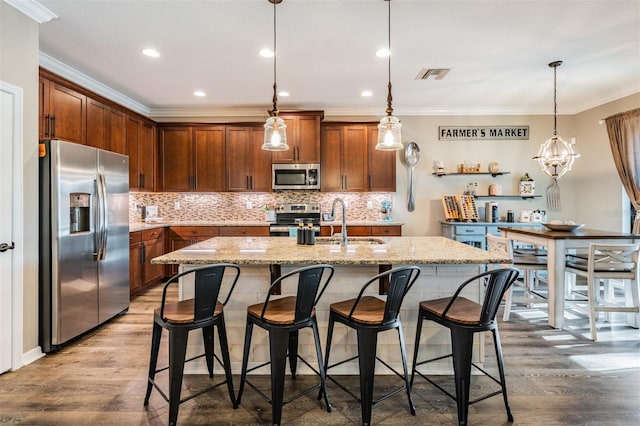 kitchen featuring stainless steel appliances, a sink, backsplash, crown molding, and wood finished floors