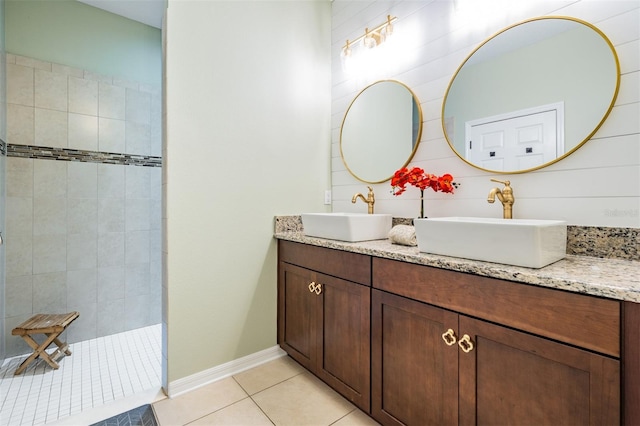 full bath with tile patterned flooring, walk in shower, double vanity, and baseboards