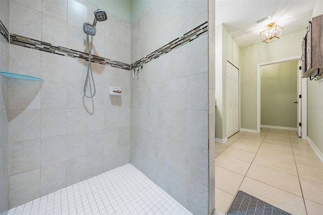 full bathroom with a tile shower, tile patterned floors, and baseboards