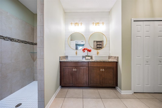full bath with a closet, tile patterned floors, and double vanity
