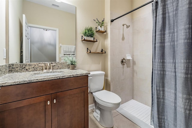 full bath featuring a tile shower, toilet, vanity, and tile patterned flooring