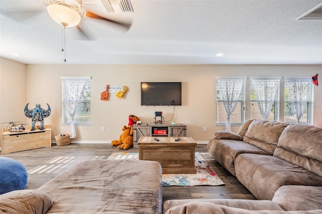 living area featuring wood finished floors, baseboards, ceiling fan, recessed lighting, and a textured ceiling