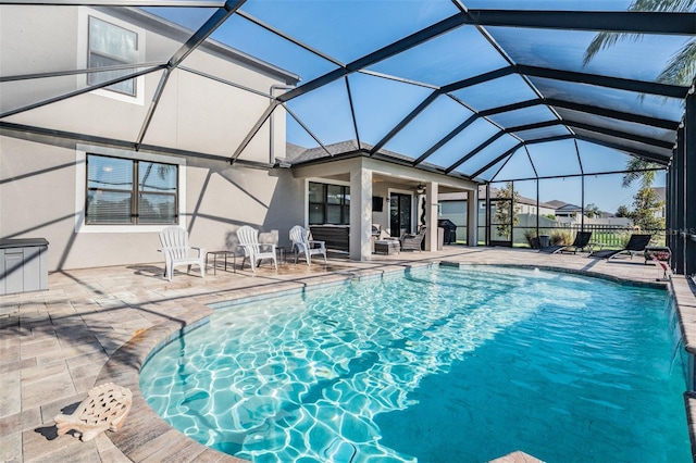 view of pool with a patio area and glass enclosure