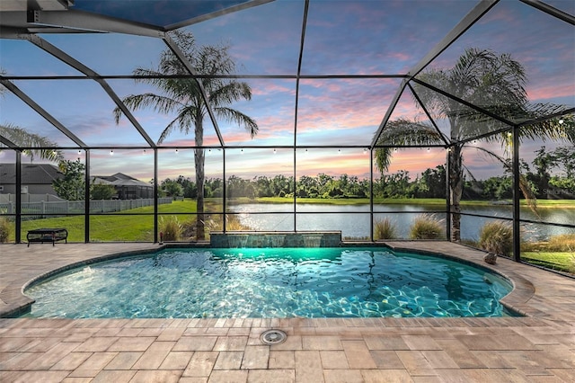 pool at dusk featuring a patio, a water view, an outdoor pool, and a lanai