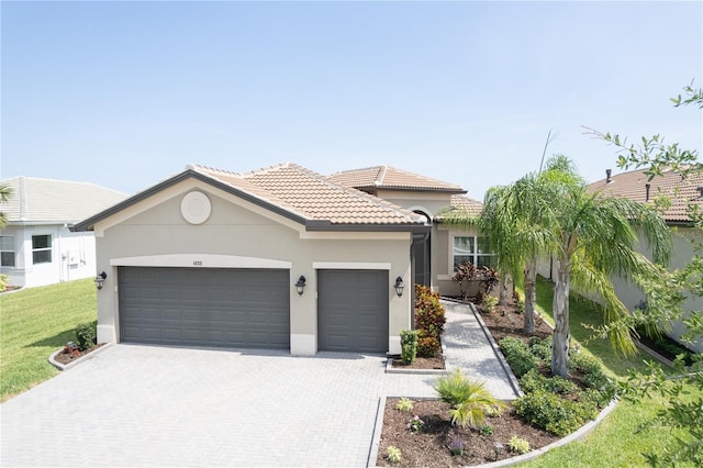 4888 Sevilla Shores Dr, Wimauma, FL 33598 - mediterranean / spanish house with an attached garage, decorative driveway, stucco siding, a tiled roof, and a front lawn
