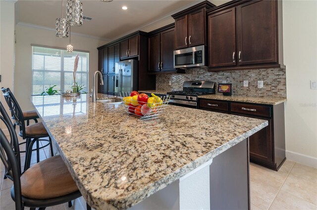4888 Sevilla Shores Dr, Wimauma, FL 33598 - kitchen featuring stainless steel appliances, a sink, tasteful backsplash, ornamental molding, and a large island