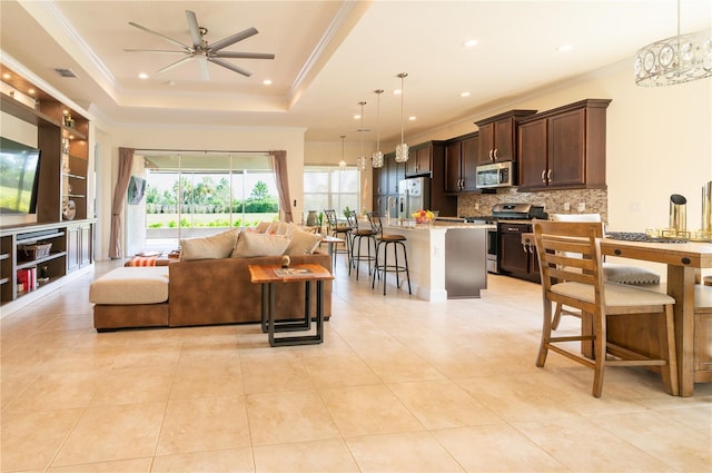 4888 Sevilla Shores Dr, Wimauma, FL 33598 - living room with a ceiling fan, crown molding, light tile patterned flooring, recessed lighting, and a tray ceiling
