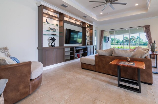 4888 Sevilla Shores Dr, Wimauma, FL 33598 - living room with a ceiling fan, crown molding, built in shelves, light tile patterned floors, and a tray ceiling