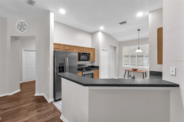 11808 Holly Crest Ln, Riverview, FL 33569 - kitchen featuring appliances with stainless steel finishes, dark countertops, a peninsula, wood finished floors, and vaulted ceiling