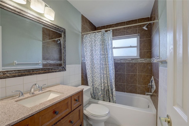 full bathroom with tile walls, toilet, shower / bath combo, and vanity