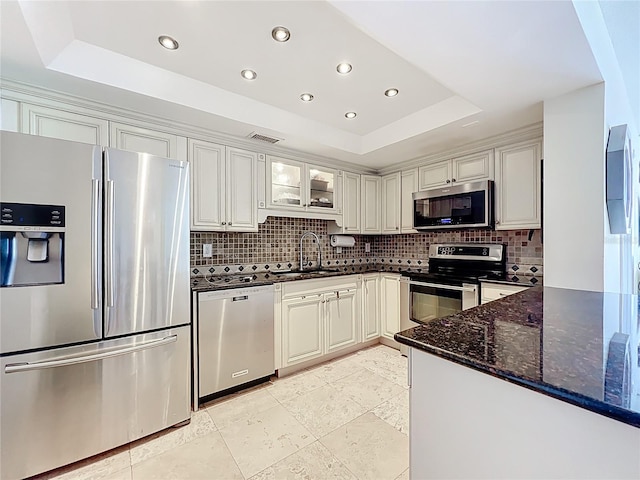 100 Pierce St Unit 910, Clearwater, FL 33756 - kitchen featuring appliances with stainless steel finishes, a tray ceiling, backsplash, dark stone countertops, and recessed lighting