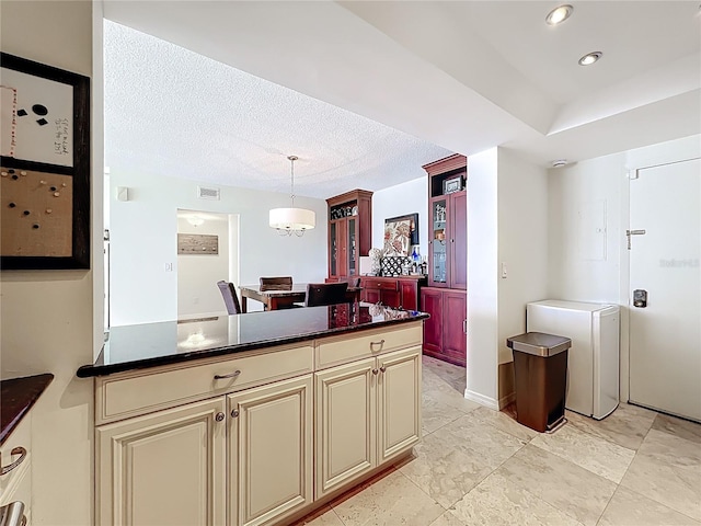 100 Pierce St Unit 910, Clearwater, FL 33756 - kitchen featuring cream cabinets, dark countertops, hanging light fixtures, a textured ceiling, and recessed lighting