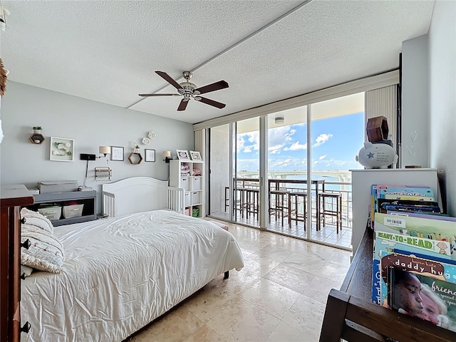 100 Pierce St Unit 910, Clearwater, FL 33756 - bedroom with access to exterior, floor to ceiling windows, a water view, a textured ceiling, and a ceiling fan