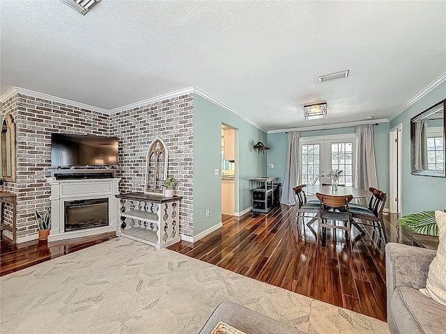 3093 Hillside Ln, Safety Harbor, FL 34695 - living area featuring crown molding, wood finished floors, a glass covered fireplace, plenty of natural light, and french doors