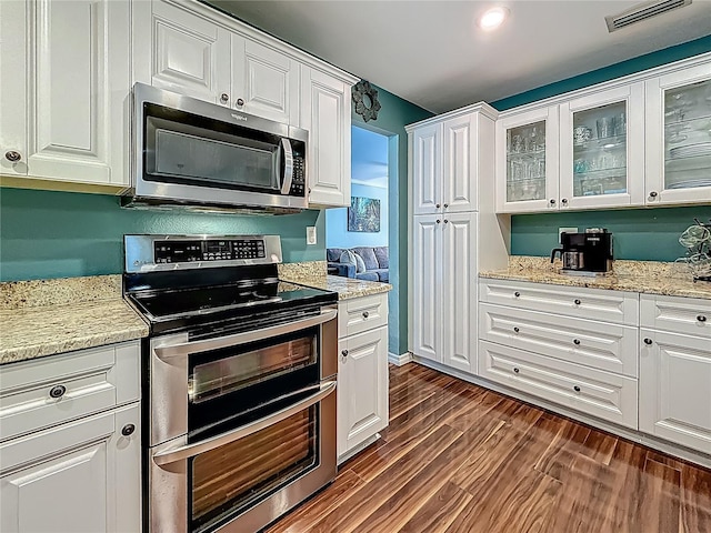 3093 Hillside Ln, Safety Harbor, FL 34695 - kitchen with appliances with stainless steel finishes, white cabinetry, glass insert cabinets, dark wood finished floors, and light stone countertops