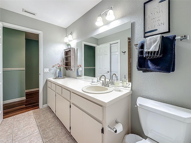 3093 Hillside Ln, Safety Harbor, FL 34695 - bathroom featuring a textured wall, toilet, vanity, and tile patterned flooring