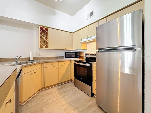 200 4th Ave S Unit 229, Saint Petersburg, FL 33701 - kitchen with stainless steel appliances, under cabinet range hood, a sink, light wood-type flooring, and light brown cabinets