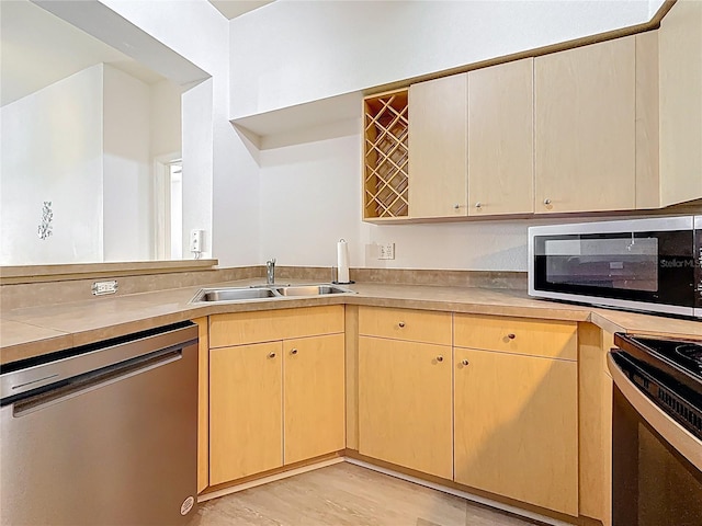 200 4th Ave S Unit 229, Saint Petersburg, FL 33701 - kitchen featuring stainless steel appliances, a sink, light brown cabinets, light countertops, and light wood-type flooring