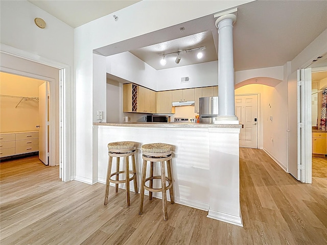 200 4th Ave S Unit 229, Saint Petersburg, FL 33701 - kitchen featuring appliances with stainless steel finishes, light wood-type flooring, a peninsula, arched walkways, and ornate columns