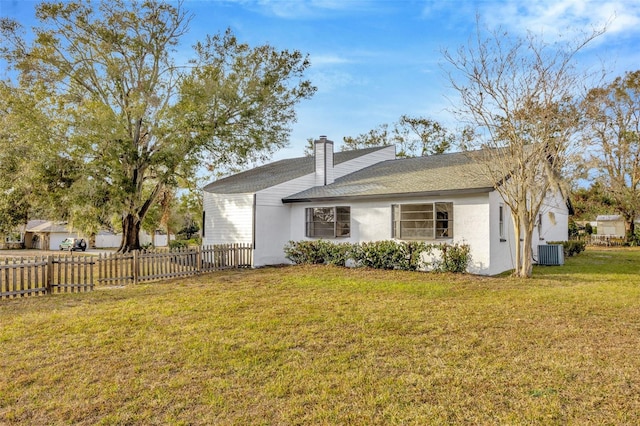 back of property featuring central AC unit, stucco siding, and a chimney