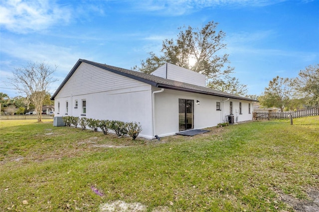 rear view of property with central AC, stucco siding, a chimney, and roof with shingles