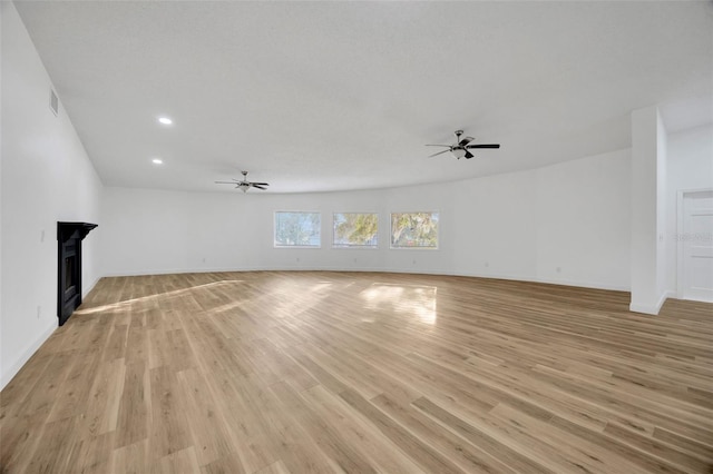 unfurnished living room featuring ceiling fan, recessed lighting, light wood finished floors, baseboards, and a fireplace