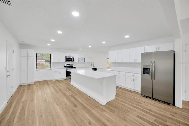 kitchen with stainless steel appliances, a sink, tasteful backsplash, recessed lighting, and light countertops