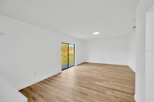 spare room with light wood finished floors, baseboards, and recessed lighting