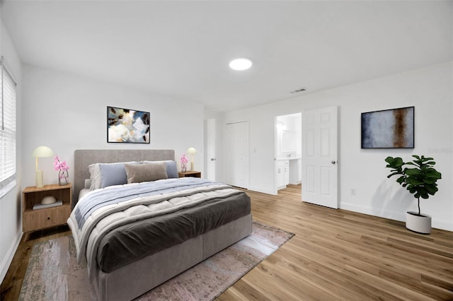 bedroom featuring baseboards, light wood finished floors, and a closet