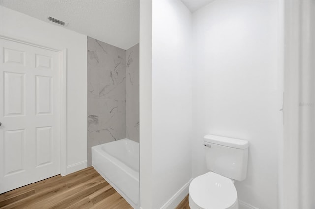 full bathroom featuring wood finished floors, baseboards, and toilet